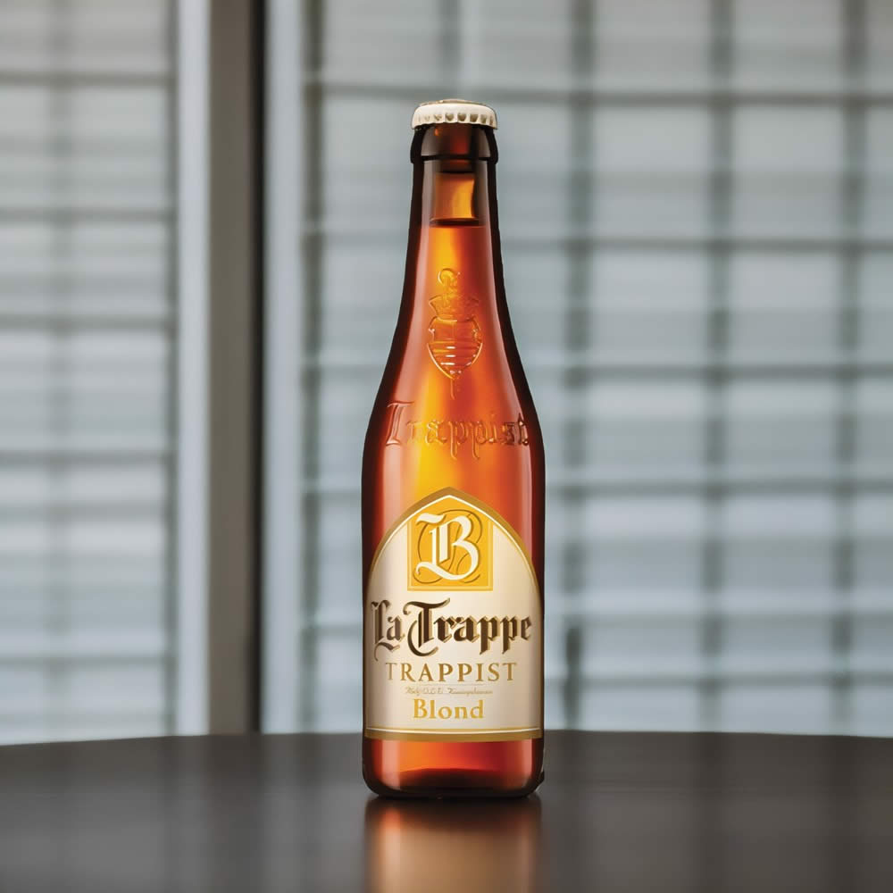 Cerveza La Trappe Blonde sobre mesa café