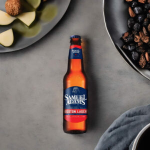 Cerveza Samuel Adams Boston Lager en mesa con platos