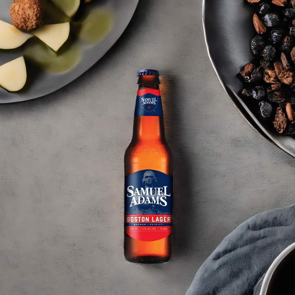 Cerveza Samuel Adams Boston Lager en mesa con platos